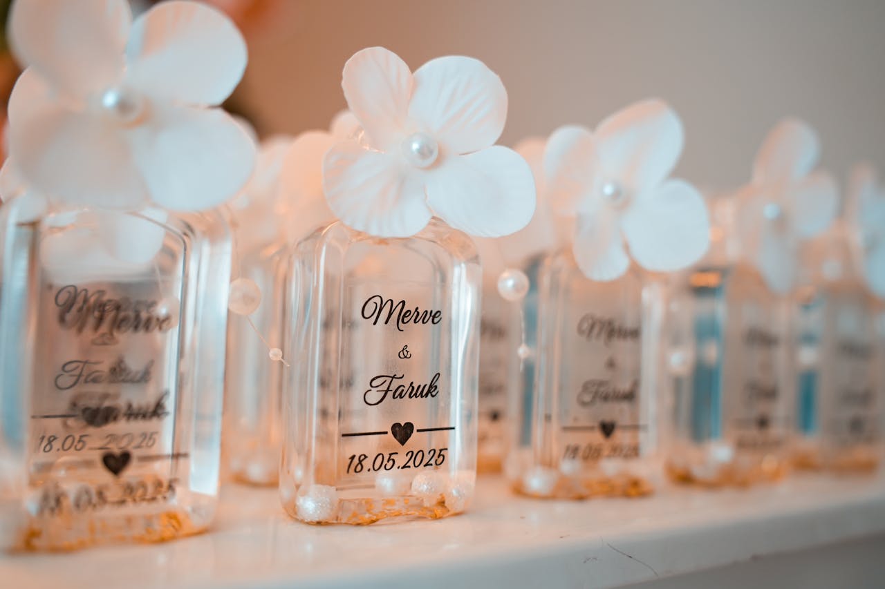 gallery-3 Close-up of elegant personalized wedding favor bottles with flowers and text.